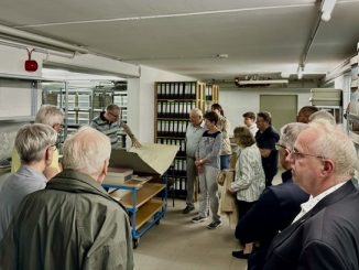 Gruppe betrachtet Archivmaterialien in Bibliothek