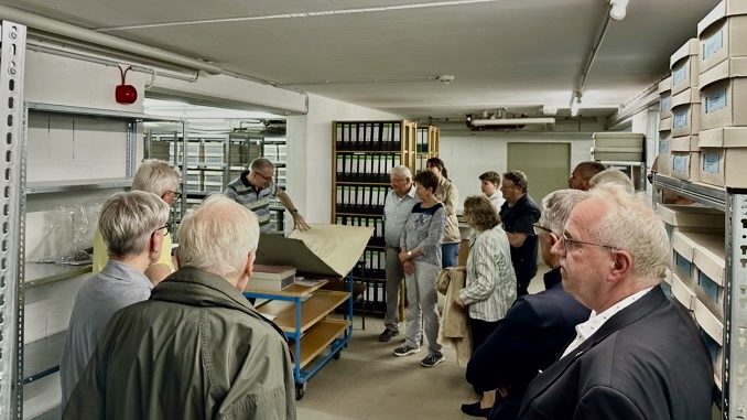 Gruppe betrachtet Archivmaterialien in Bibliothek